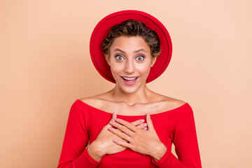 Wall Mural - Photo of astonished nice happy woman hold hands chest wear cool hat winner unexpected isolated on beige color background