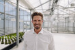 © KNSY/Westend61 - Smiling male owner standing in greenhouse