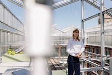Smiling Female Professional Looking Away While Standing In Greenhouse