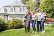 © MiJo/Westend61 - Happy extended family standing in garden of their home