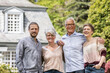 © MiJo/Westend61 - Happy senior couple with adult children standing in garden of their home