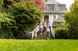 © MiJo/Westend61 - Extended family walking on stairs in garden of their home
