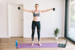 © Elena Medoks - Young beautiful girl is engaged with dumbbells at home.