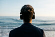© Josep Rovirosa/Westend61 - Afro man with headphones at beach