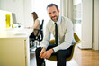 © Mike Schaefer/Westend61 - Portrait of confident businessman in office with employee in background