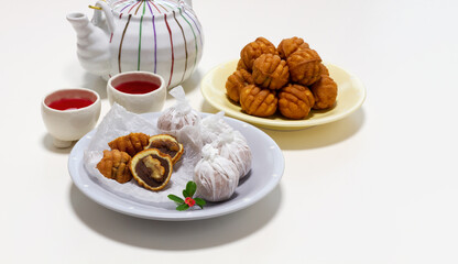 Small walnut-flavored cakes in the size and shape of a walnut on the plate. Dessert table setting with copy space isolate on white background. 
