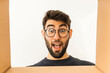 © Thomas Degen/Westend61 - Portrait of surprised young man with beard and glasses looking into cardboard box