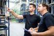 © Pavel Horak/Westend61 - Worker with colleague in factory warehouse pointing his finger