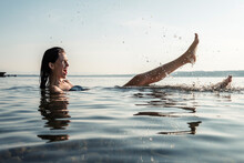 Young Woman Bathing In Lake Starnberg, Splashing With Water, Germany
