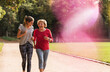 © UWE_UMSTAETTER/Westend61 - Granddaughter and grandmother having fun, jogging together in the park
