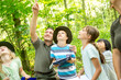 © Fotoagentur WESTEND61/Westend61 - School children exploring the forest, teacher pointing up