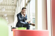 © UWE_UMSTAETTER/Westend61 - Young businessman sitting in lounge, using digital tablet