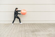 © UWE_UMSTAETTER/Westend61 - Young man in leather jacket, playing with a gym ball