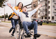 © UWE_UMSTAETTER/Westend61 - Portrait of young woman pushing senior man in wheelchair on pavement
