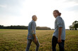 © KNSY/Westend61 - Happy father and adult son walking on a meadow in the countryside