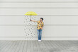 © UWE_UMSTAETTER/Westend61 - Digital composite of young man holding an umbrella at a wall with raindrops