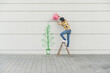 © UWE_UMSTAETTER/Westend61 - Digital composite of young man watering flower at a wall