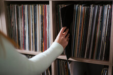 Woman Collecting Record From Shelf At Music Store