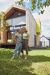 © Maya Claussen/Westend61 - Romantic couple looking at each other while standing against house in yard