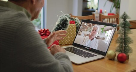 Canvas Print - Happy caucasian senior man on video call on laptop with senior female friend at christmas time