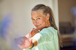 © Maya Claussen/Westend61 - Smiling woman exercising with resistance band at home