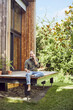 © Maya Claussen/Westend61 - Bearded mature man talking over mobile phone while sitting outside tiny house