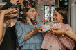 © Mareen Fischinger/Westend61 - Friends throwing confetti on teenager giving gift to birthday girl in party