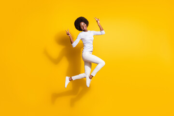 Canvas Print - Full body photo of attractive young dark skin woman jump up show v-signs isolated on yellow color background