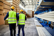 © Dangubic/Westend61 - Rear view of two workers carrying boxes in factory warehouse