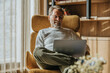 © Mareen Fischinger/Westend61 - Smiling mature man working on laptop while sitting on chair