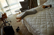 © Dangubic/Westend61 - Tired businesswoman lying on bed in hotel room