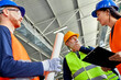 © Dangubic/Westend61 - Colleagues in protective workwear talking in factory