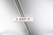 © Nadine Ginzel/Westend61 - Exit sign on white airplane ceiling