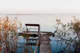 Fototapeta Pomosty - Drewniany pomost nad jeziorem, mglisty poranek nad jeziorem z pomostem, ławeczka nad jeziorem, wschód słońca nad jeziorem z pomostem 