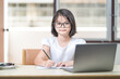 © EduLife Photos - Asian children girl student with eyeglasses studying online, doing homework on laptop at home. Education Concept Stock Photo