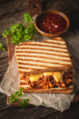 Wall Mural - Close up view of tasty sloppy joe sandwich with ground meat, sauce and cheese on wooden background