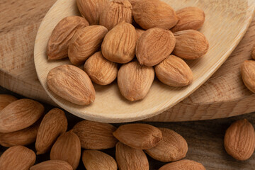 Wall Mural - peach seed nuts, on a wooden background, close up