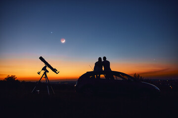 Wall Mural - Couple stargazing together with a astronomical telescope.