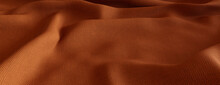 Seasonal Autumn Background With Fine Woven Cloth. Ripples And Folds Form A Tactile Orange Texture.