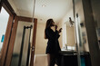 © Дмитрий Бесов - a young beautiful girl in the bathroom, she is wearing a black jacket on a naked body and high boots, the sunlight from the window brightly illuminates her