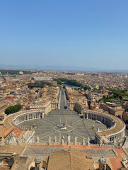 Vertical shot of Saint Peter's square and dense buildings under a blue clear sky in Rome, Italy