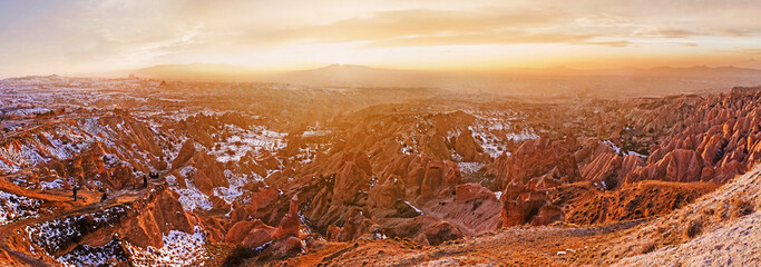 Wall Mural - The winter mountain haze lights up with golden glow during the sunset, Red Valley, Cappadocia, Turkey.