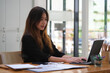 © saltdium - Photo of a young attractive girl working at the wooden table surrounded by a digital tablet and various equipment.