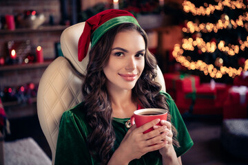 Poster - Portrait of attractive dreamy cheerful girl elf drinking latte beverage festal day at decorated home modern loft industrial interior indoors