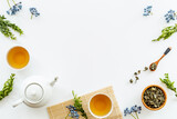 Tea drinking with white teapot and black tea in two cups