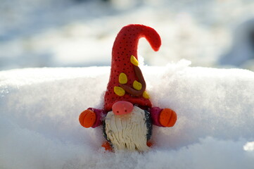 Sticker - A small gnome on the background of snow.