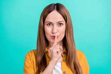 Sticker - Photo of serious confident young woman dressed yellow shirt smiling finger lips asking keep silence isolated teal color background