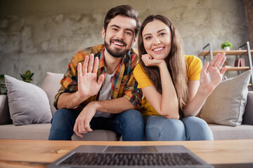 Poster - Photo of friendly beautiful young lovers dressed casual clothes talking modern gadget smiling indoors loft apartment