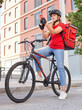 © Jose - A cyclist delivery girl checks the address of her next shipment with her mobile phone