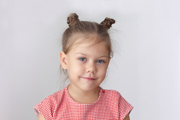 Portrait of caucasian calm little girl of five years old on the white background looking at camera